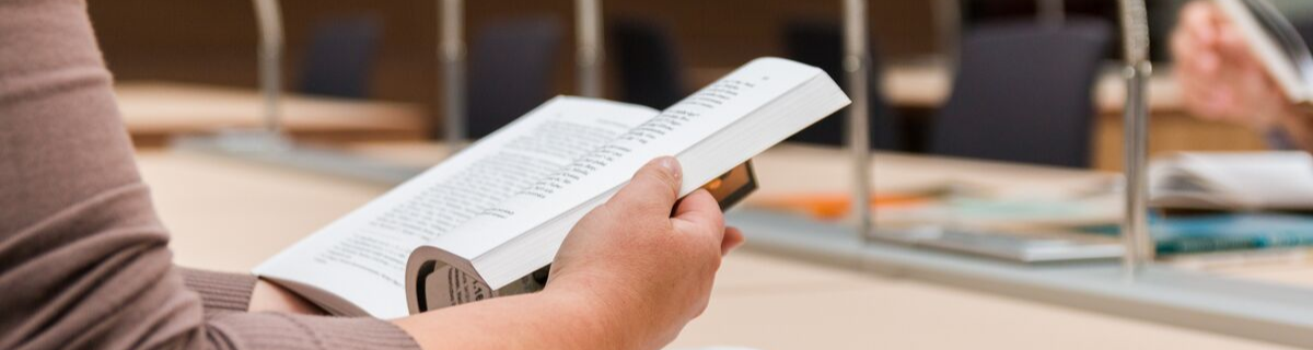  hands reading at library work desk